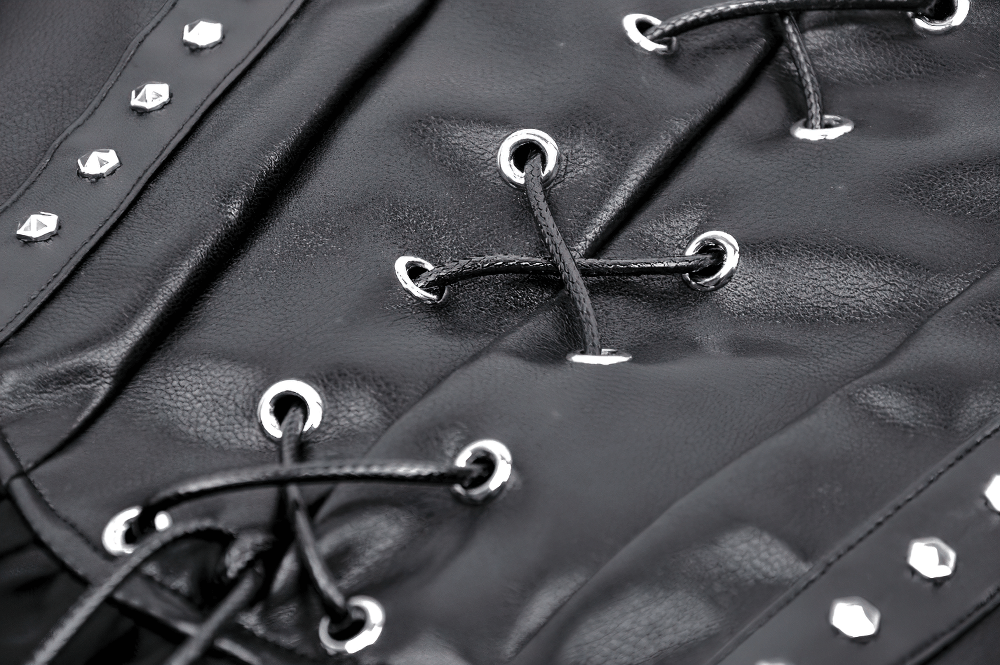Close-up of lace-up corset detail with silver studs on black fabric, highlighting edgy fashion style.