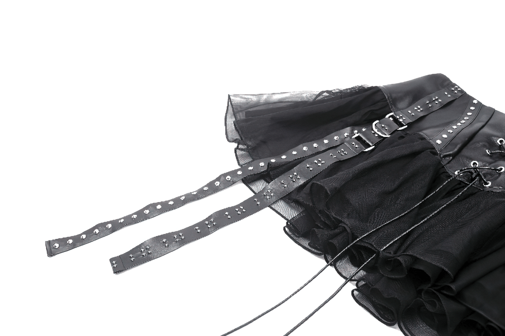 Close-up of black tulle mini skirt with lace-up front and studded straps, showcasing edgy corset detailing.