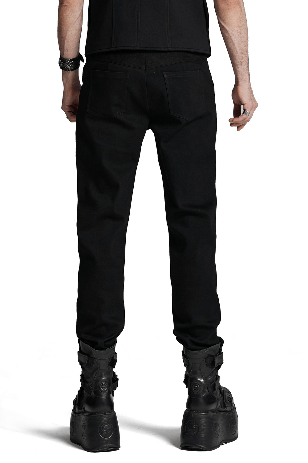 Black twill denim pants with eyelet details viewed from the back, styled with edgy footwear for a punk-inspired look.