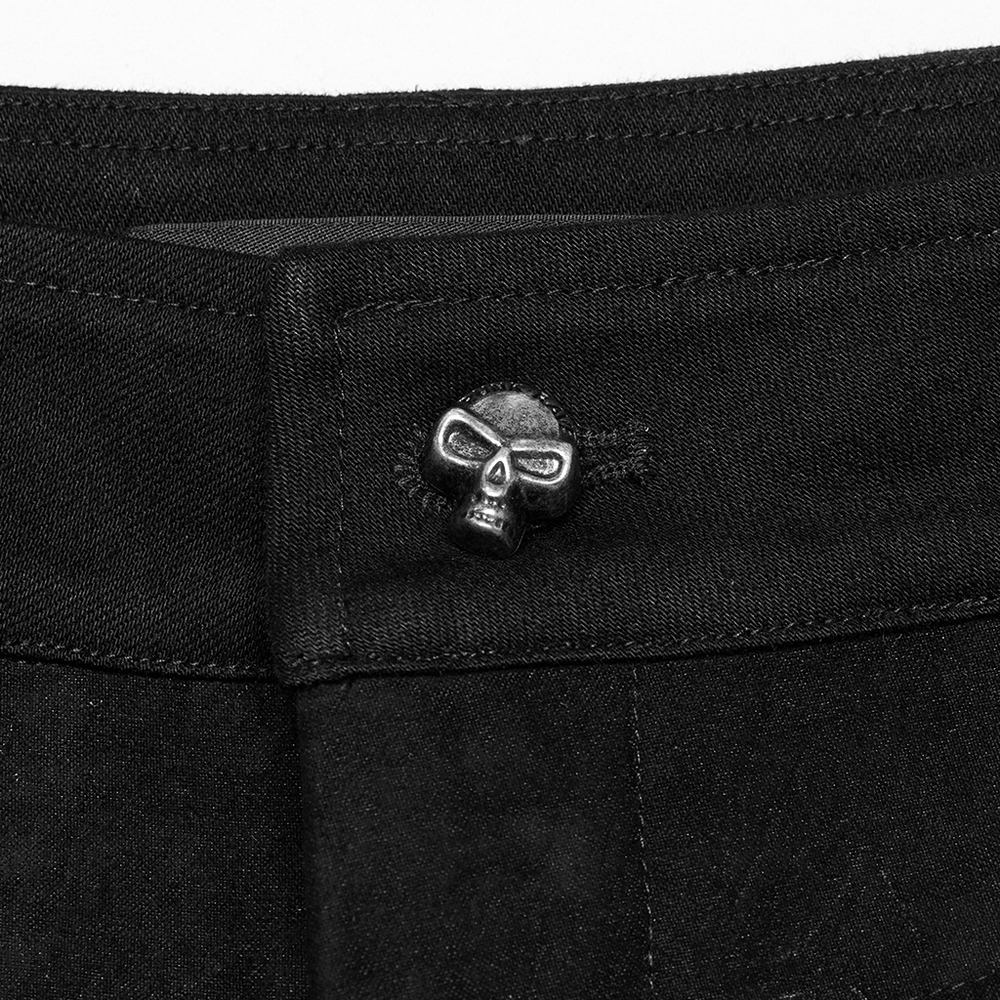 Close-up of black twill denim pants showcasing a unique skull button detail for a punk-inspired style.