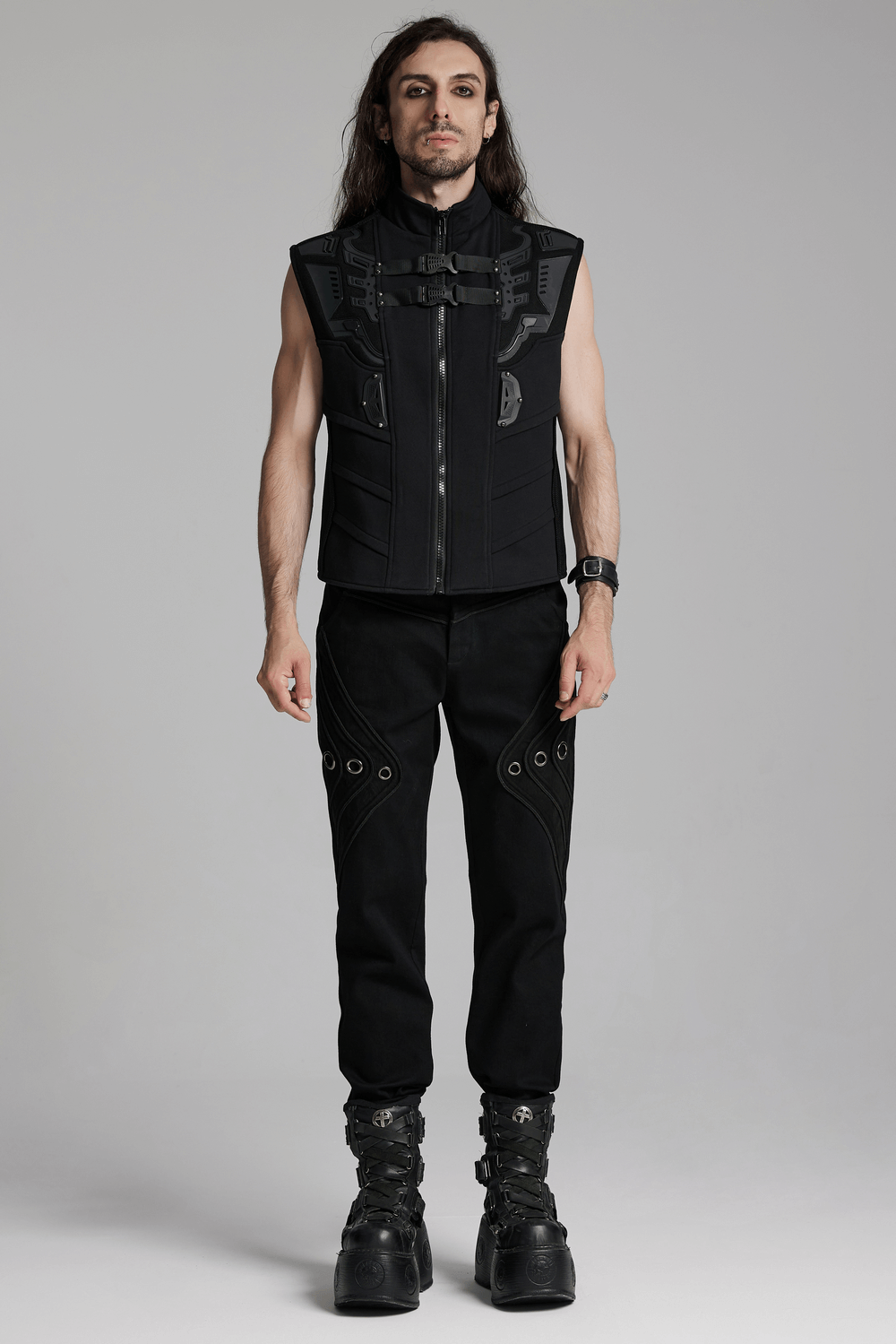 Model wearing black twill denim pants with eyelet details and a sleeveless vest, showcasing a punk-inspired style.