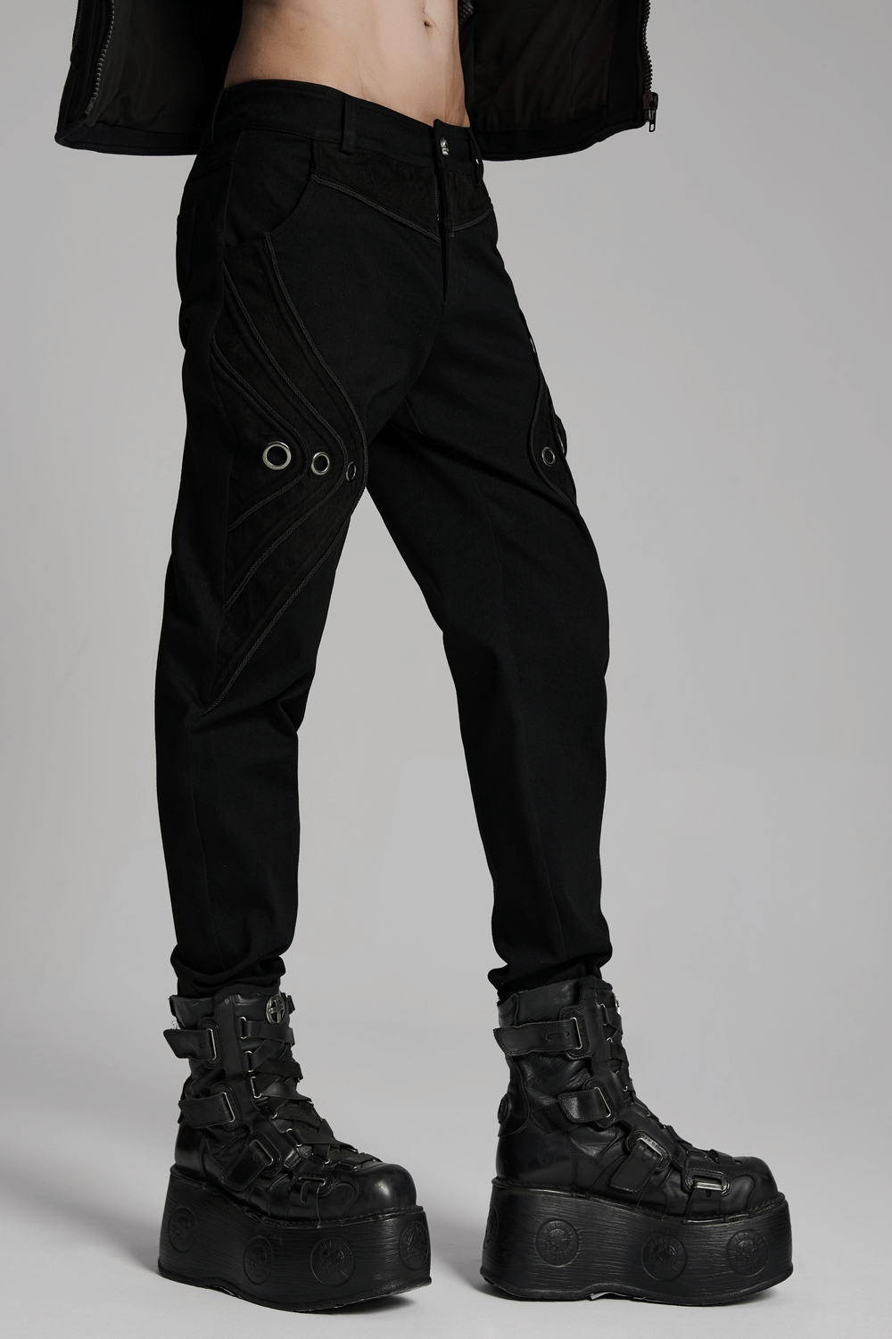 Black twill denim pants with eyelet details and punk-inspired design, paired with bold platform boots.