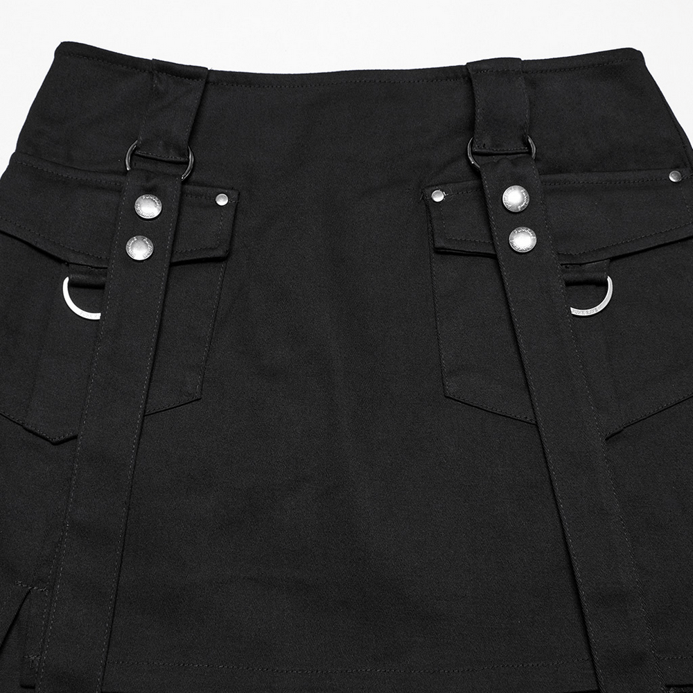 Close-up of black twill punk dress skirt featuring utility pockets, straps, and silver ring details.