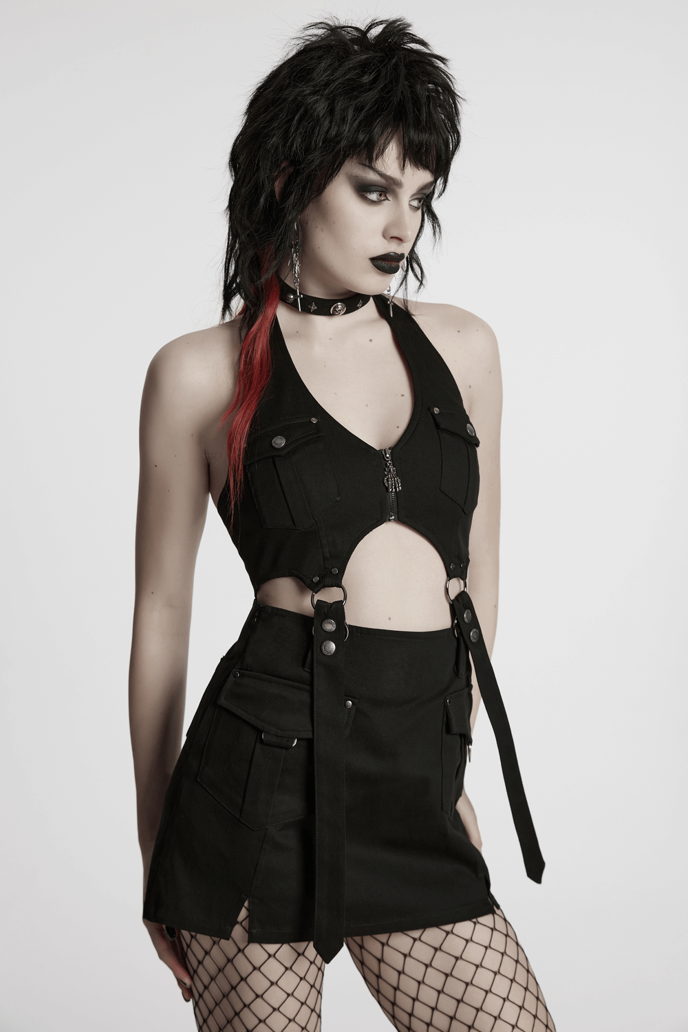 Model showcasing a black punk halter neck dress with zipper, straps, and utility pockets, exuding edgy style.