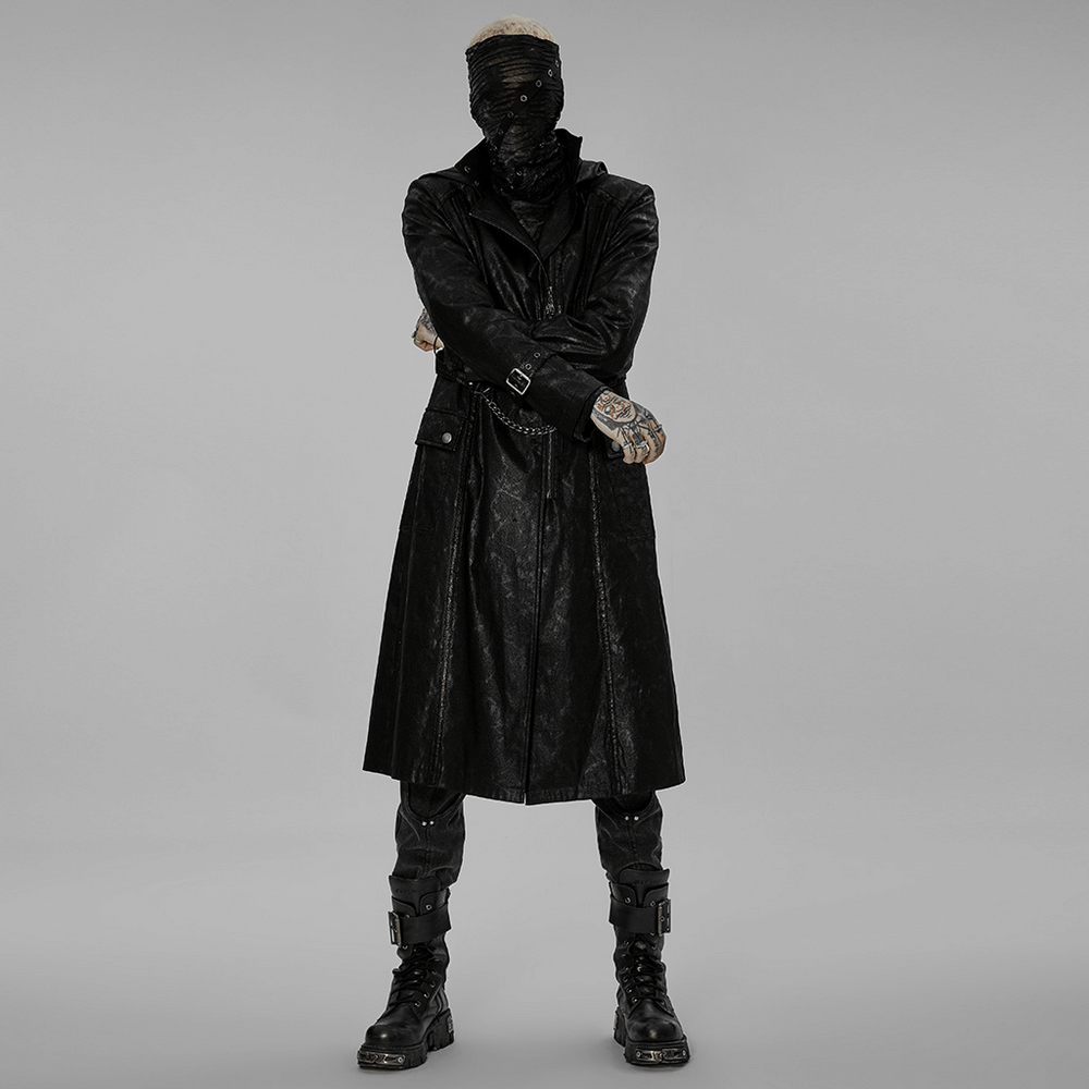Gothic punk model in a black twill hooded long coat with chain detail, showcasing edgy urban style.