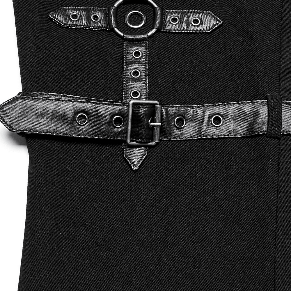 Close-up of black twill punk pants featuring metal rings, adjustable straps, and eyelet loops for an edgy style.