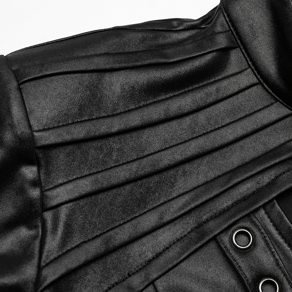 Close-up of black long sleeved top with shoulder pads and pleats, showcasing stylish leather design and chic details.