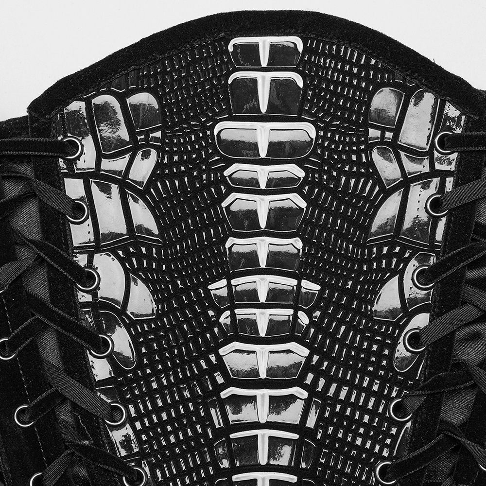 Close-up of a gothic corset belt featuring rivets and lace-up detail in black velvet and patent leather.