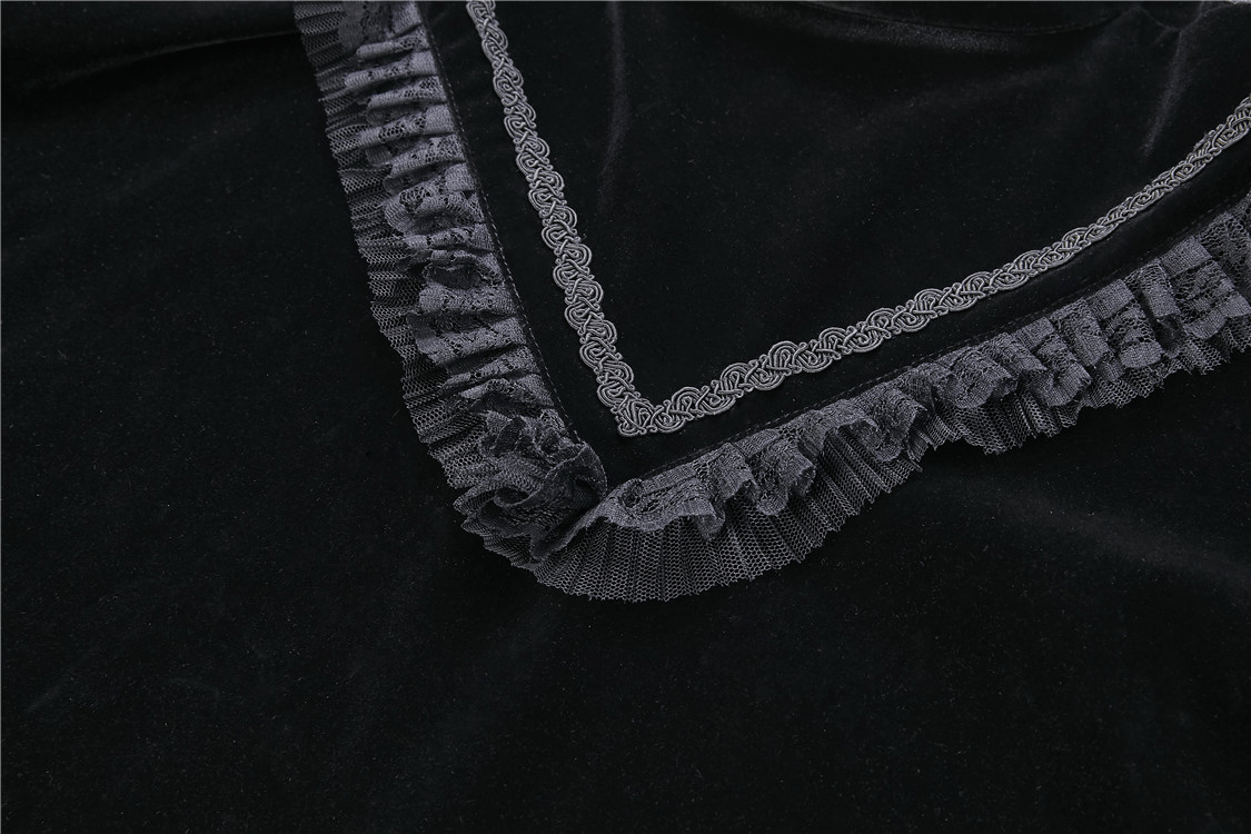 Close-up of black velvet fabric with embroidered lace trim, showcasing gothic elegance.