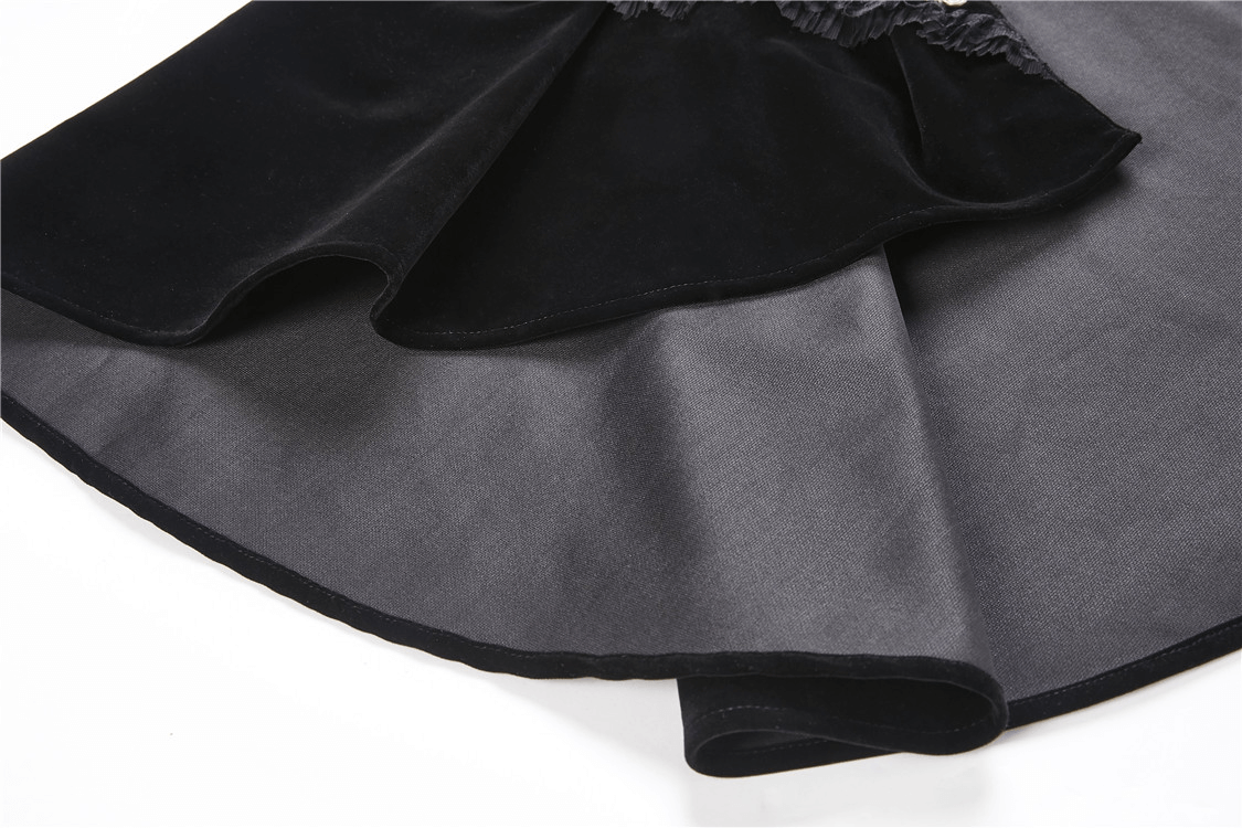 Close-up of a black velvet cape with a flowing satin interior, showcasing luxurious materials and elegant design.