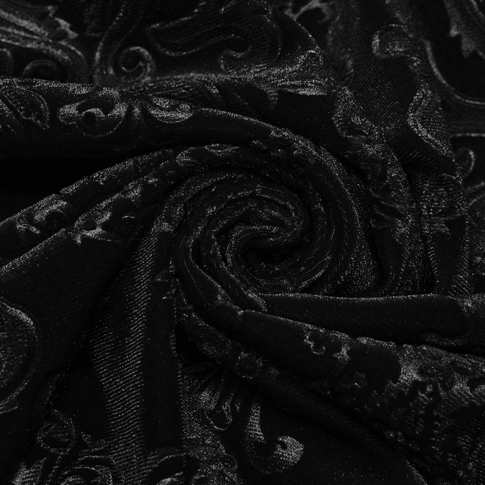 Close-up of black velvet fabric with intricate floral embossing for gothic style apparel.