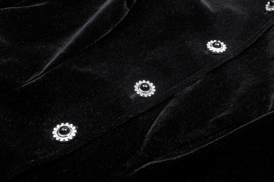 Close-up of black velvet fabric with silver and black floral buttons, perfect for a gothic coat.