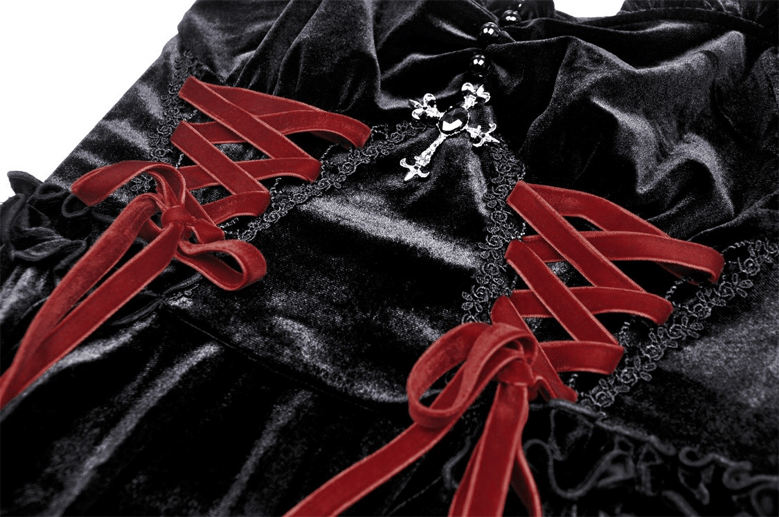 Close-up of black velvet gothic mini dress featuring red cross detail and lace accents, perfect for dark romantics.