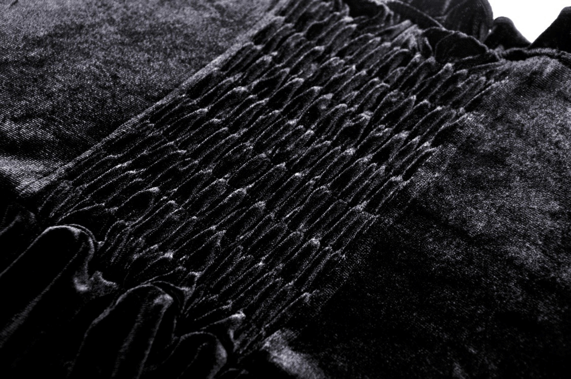 Close-up of black velvet fabric showing smocking detail for gothic mini dress.