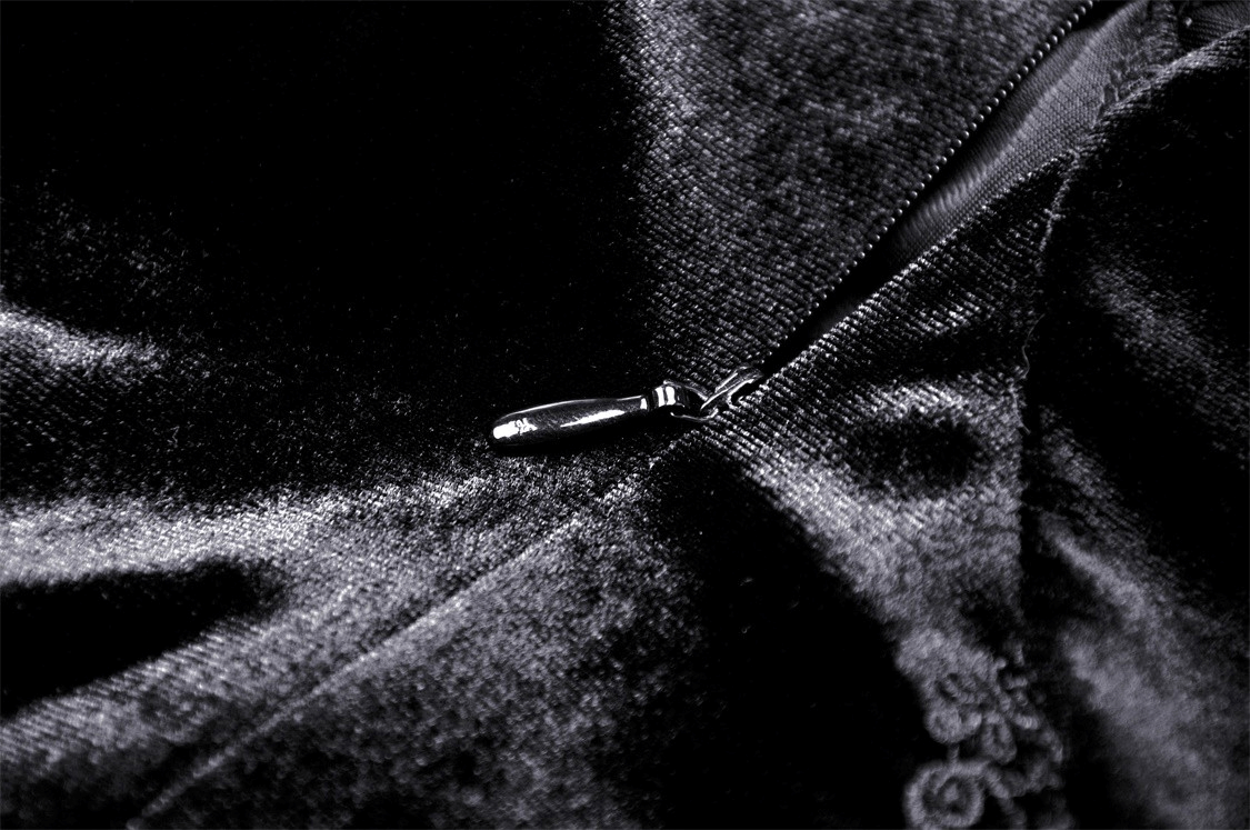 Close-up of the black velvet fabric and zipper detail on a gothic mini dress, showcasing its luxurious texture.