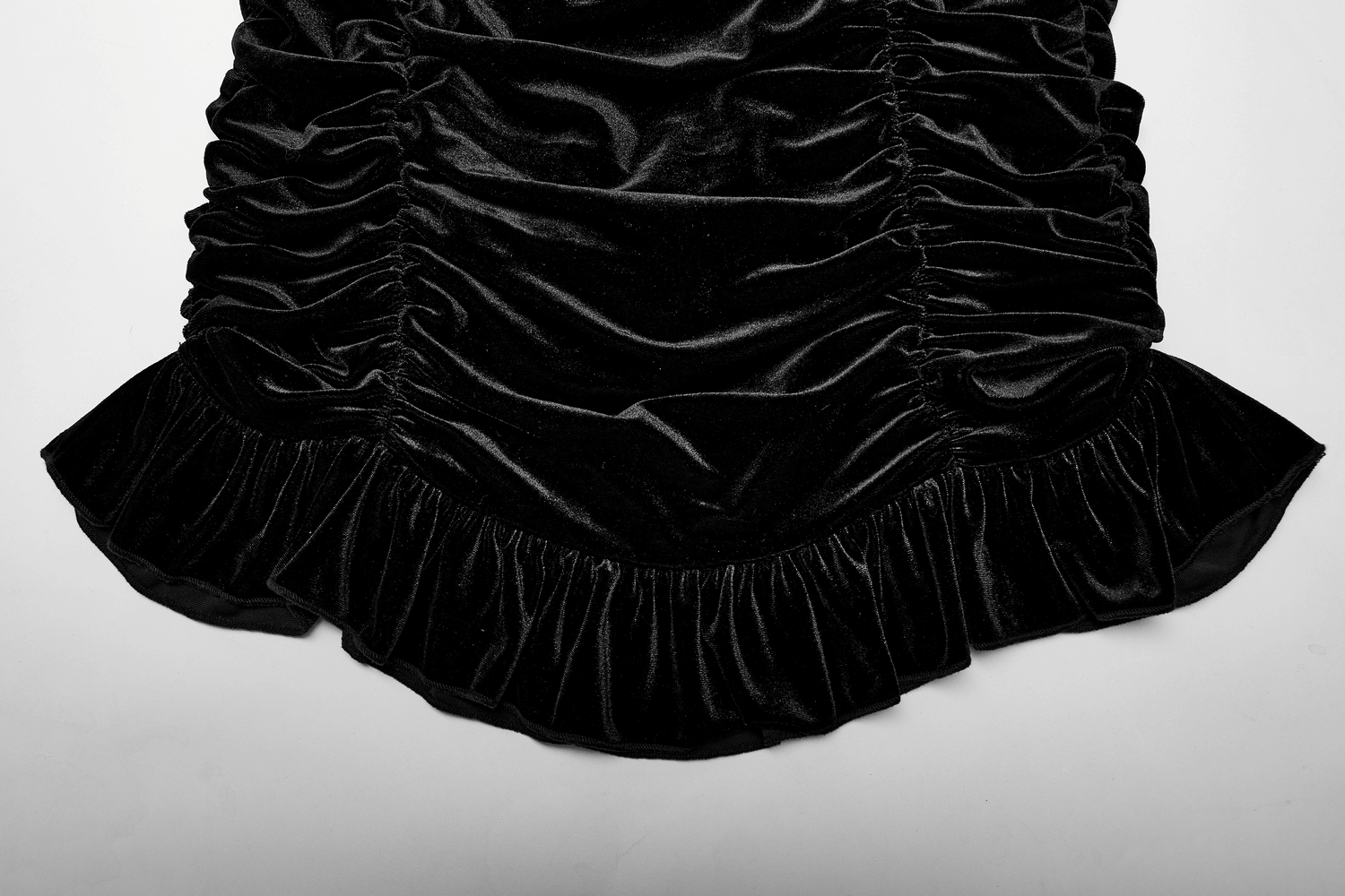Close-up of black velvet gothic mini skirt featuring ruffled hem and elegant lace accents for a Victorian flair.