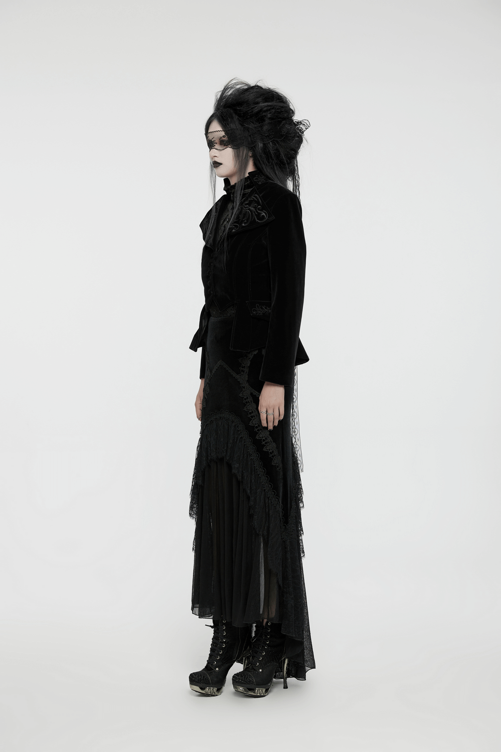 Model in a black velvet gothic tailcoat with embroidered collar and lace-up details, showcasing a dramatic aristocratic style.
