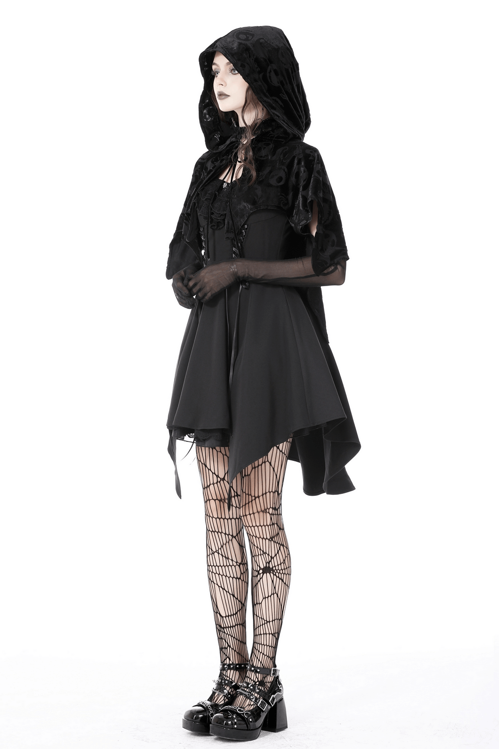 Gothic black velvet hooded cape with skull print, paired with fishnet tights for a spooky chic look.