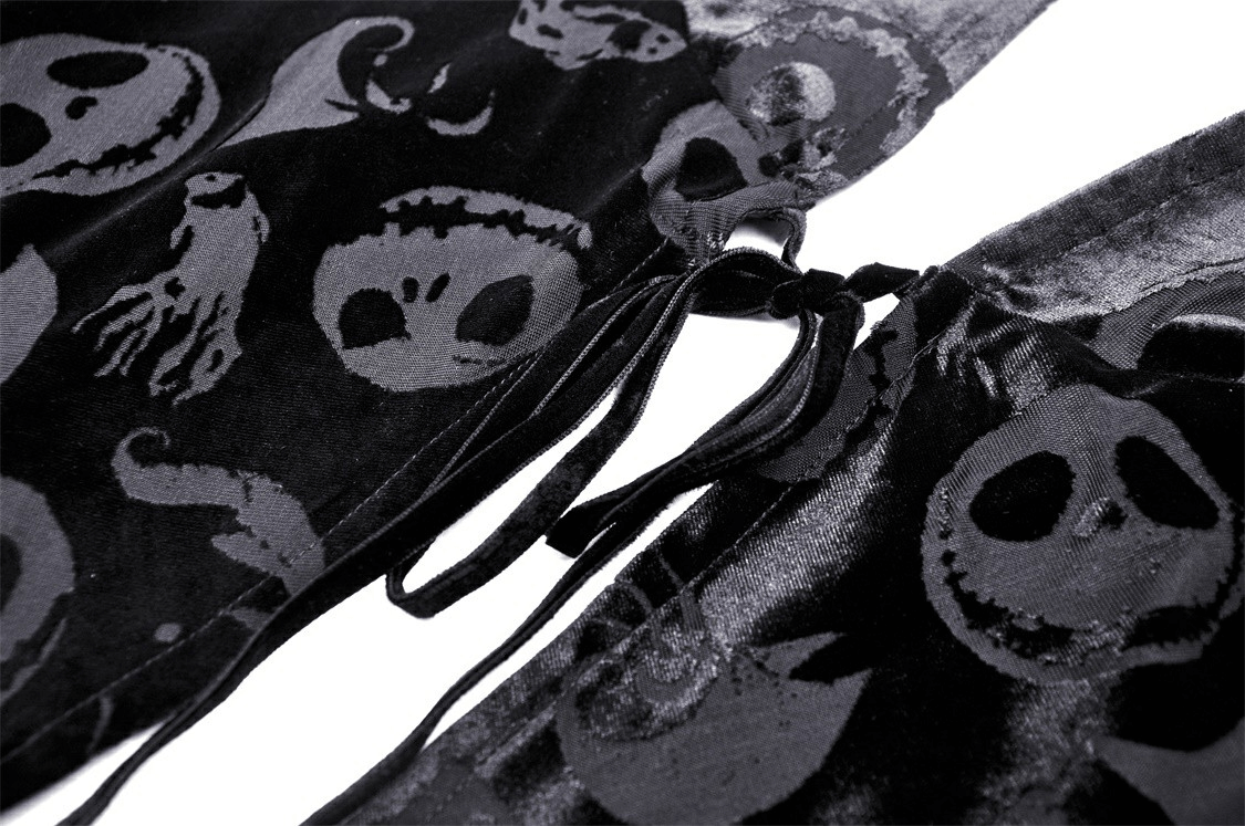 Close-up of black velvet hooded cape featuring festive skull print design, inspired by gothic themes and Halloween.