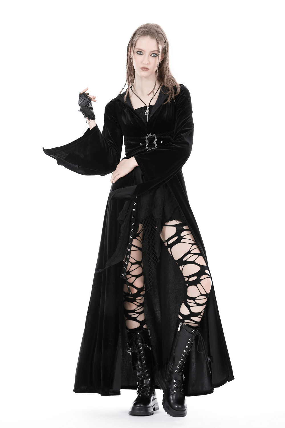 Stylish model in a black velvet hooded cloak with laced leggings, showcasing a gothic witchy vibe.