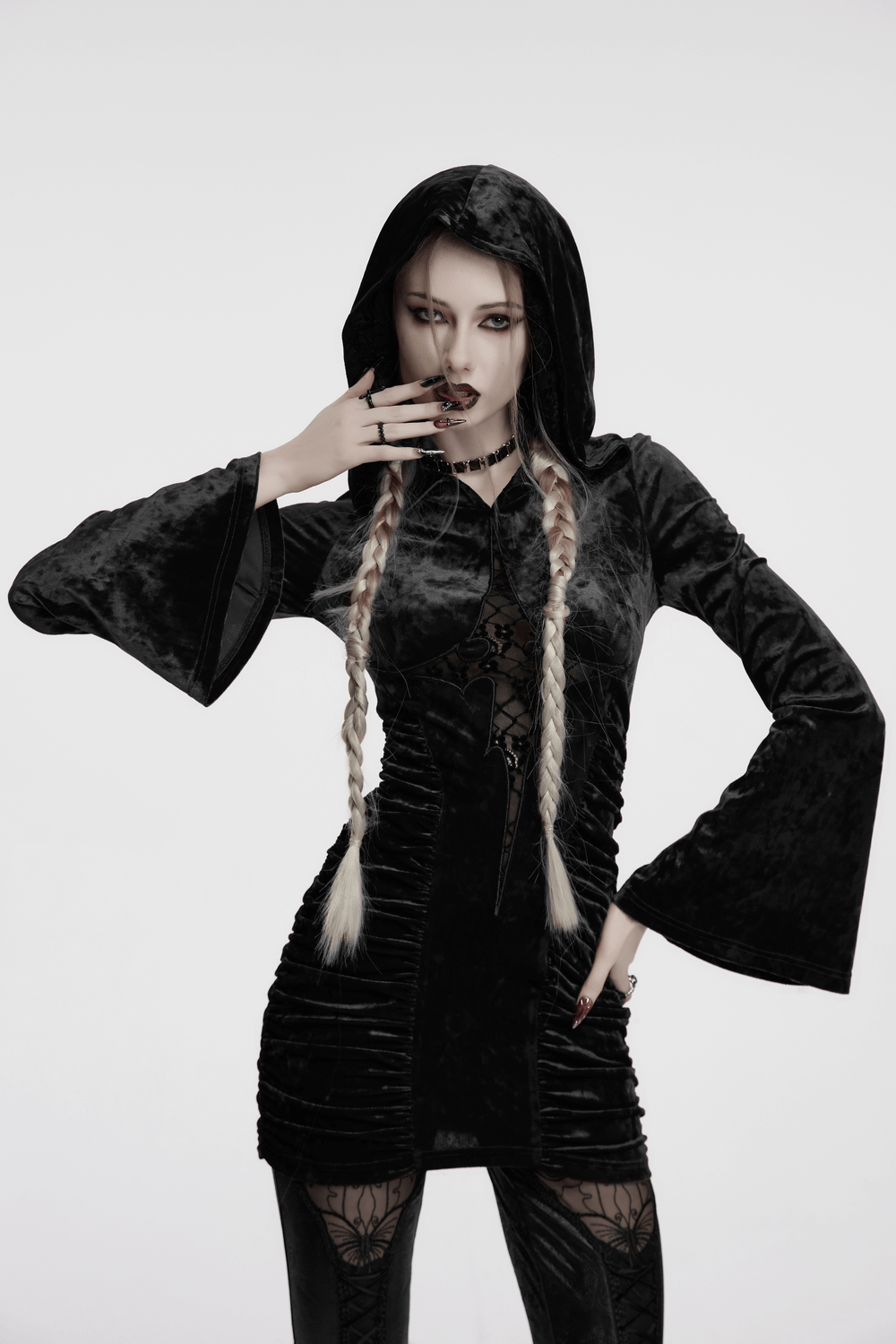 Model in a hooded black velvet lace cross dress with ruched waist, exuding gothic elegance.