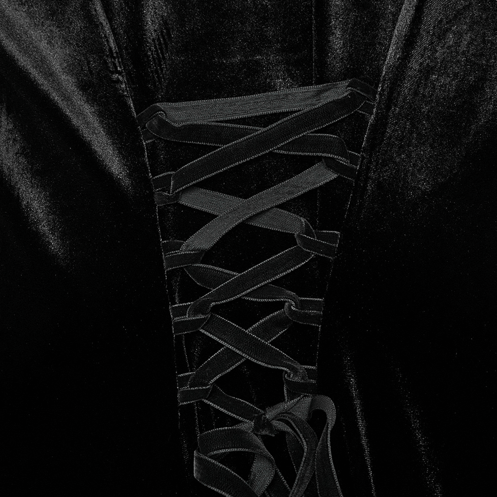 Close-up of black velvet lace-up dress with intricate lacing detail and soft gradient texture.