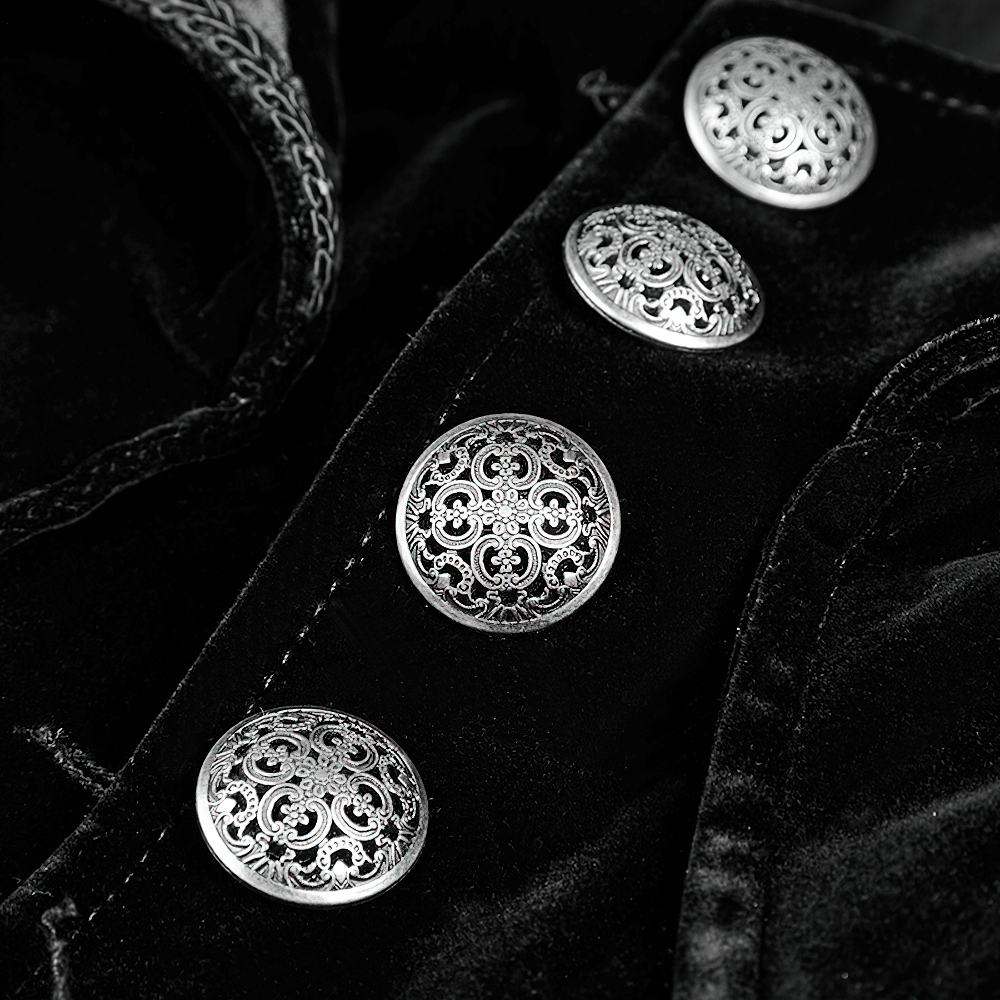 Close-up of silver ornate buttons on a black velvet Gothic trench coat, showcasing intricate craftsmanship and style.