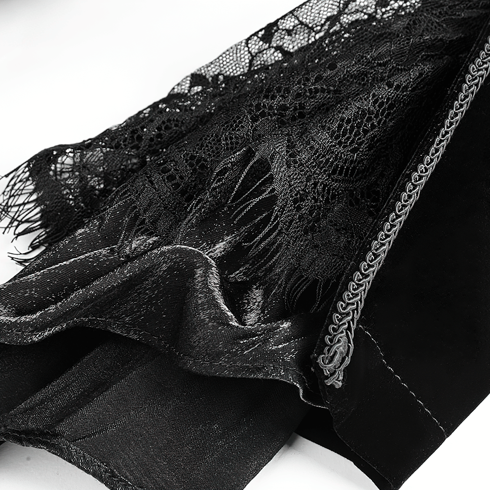 Close-up of luxurious black velvet fabric with intricate lace and fringe details, perfect for gothic fashion enthusiasts.