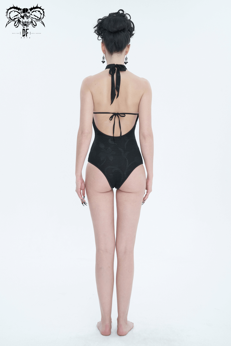 Back view of a black vintage cutout one-piece swimsuit with lace ruffle and bowtie accents.