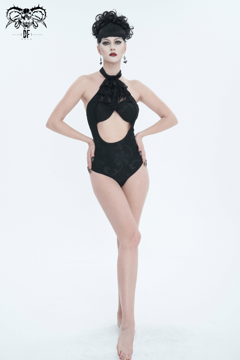 Model in black vintage cutout one-piece swimsuit with lace ruffle and bowtie, showcasing gothic beach style.