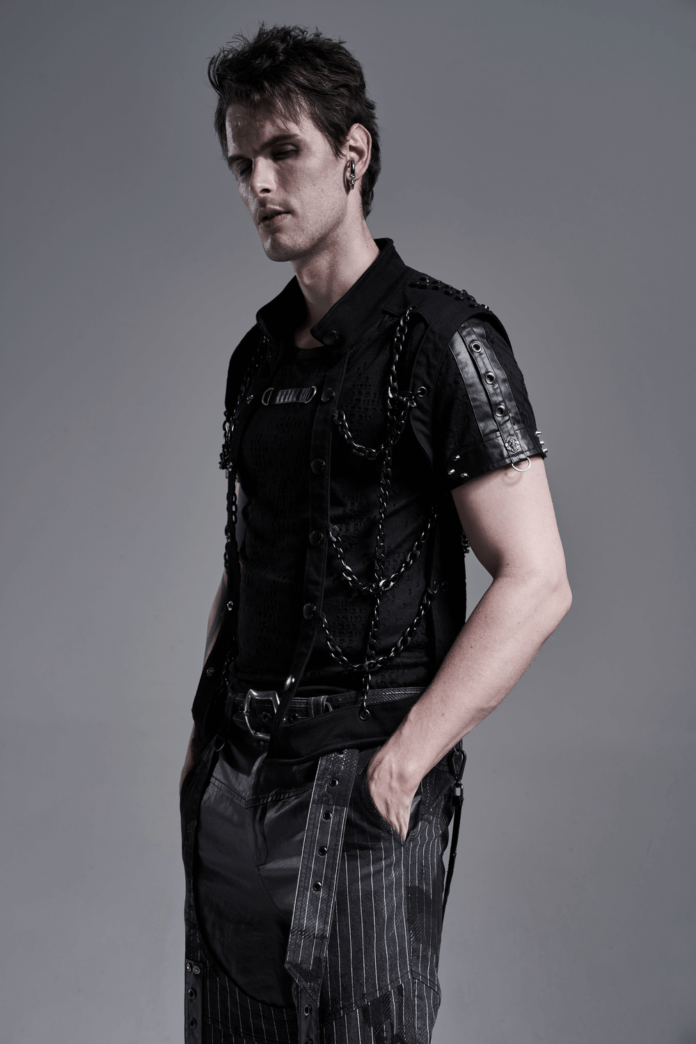 Model showcasing a black warlock chain waistcoat in a punk rave style, featuring edgy chain details and a sleek look.