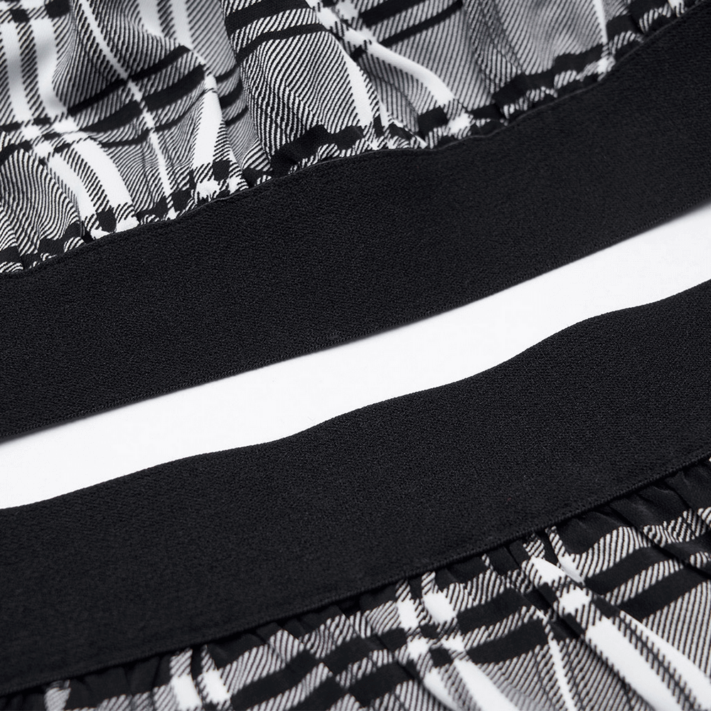 Close-up of black and white plaid fabric showing ruffled hem and waistband of detachable punk gothic dress.