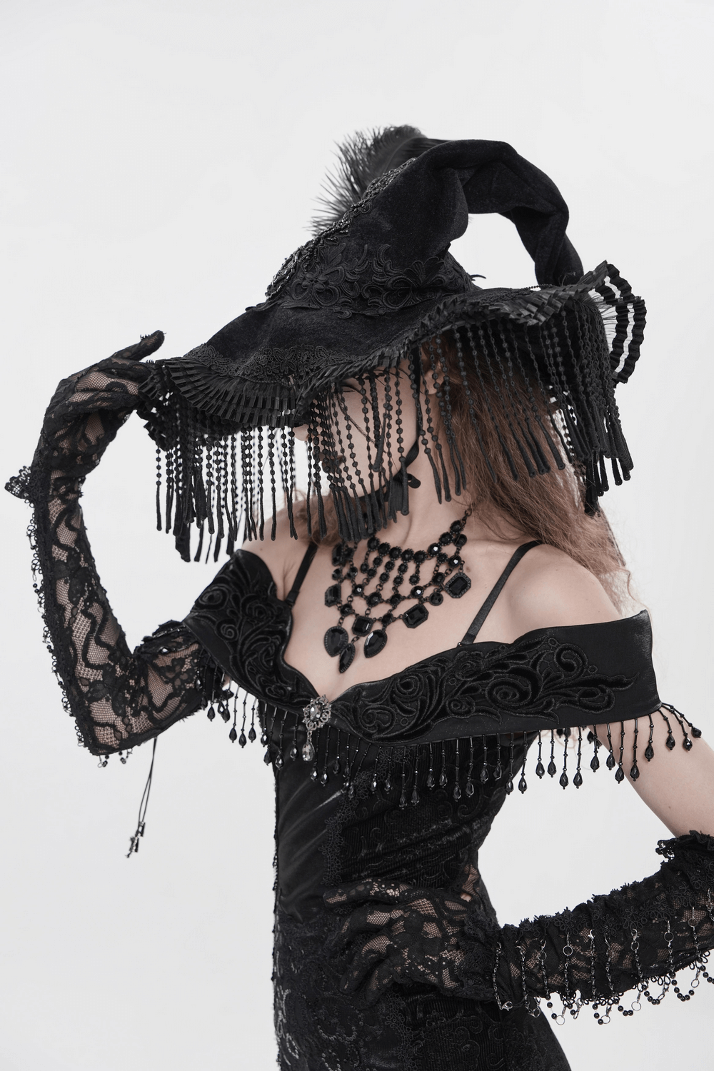 Black Witch Hat with Lace Fringe and Feather Detail worn by a model in gothic attire, showcasing elegance and style.