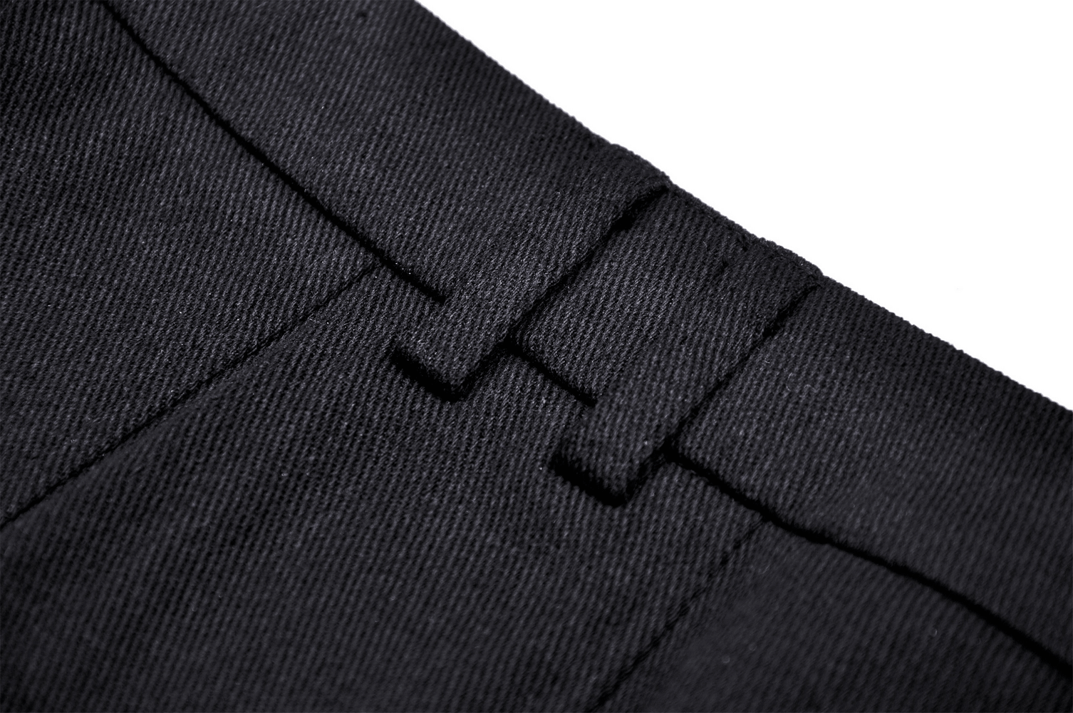 Close-up of the waistband of a black dress fabric, featuring detailed stitching and a classic buckle design.