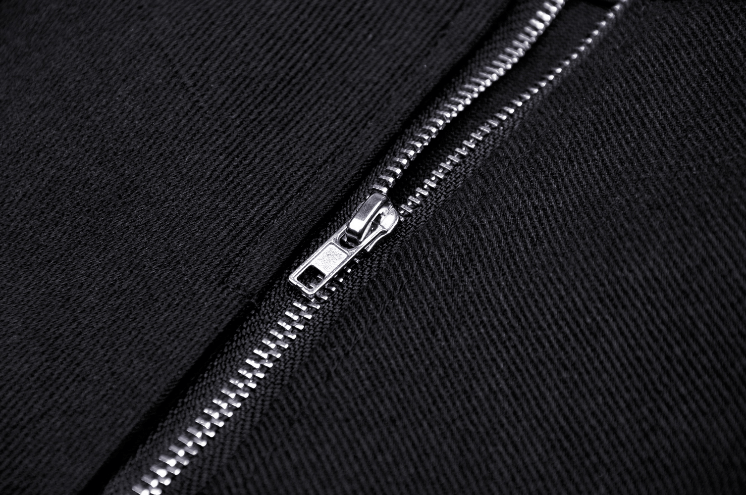 Close-up of a sleek black zipper on a dark fabric, showcasing quality craftsmanship and detail.