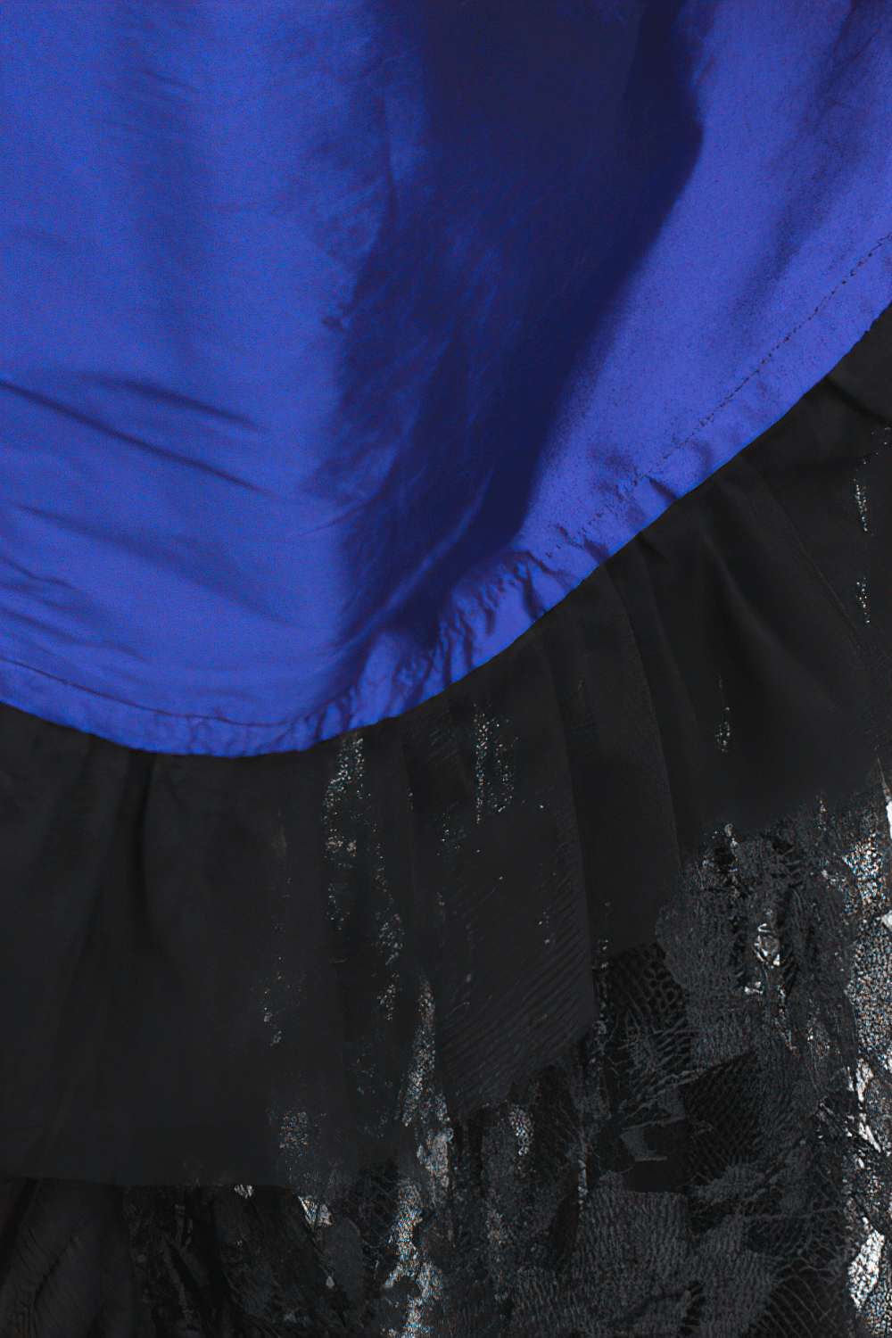 Close-up of blue Victorian bustle skirt showcasing glossy taffeta and dramatic black lace layers for vintage elegance.