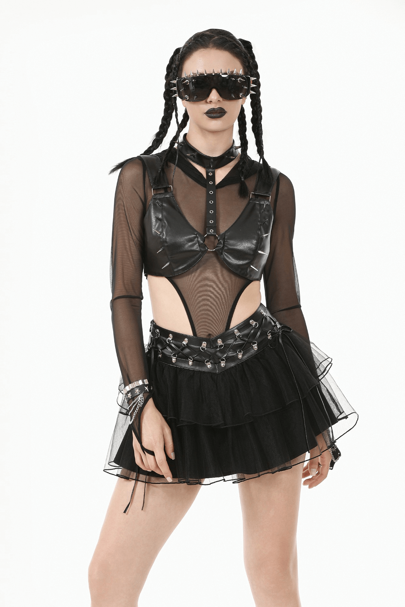 Gothic model wearing a black mesh top, faux leather bra, and layered tulle skirt for edgy punk fashion style.