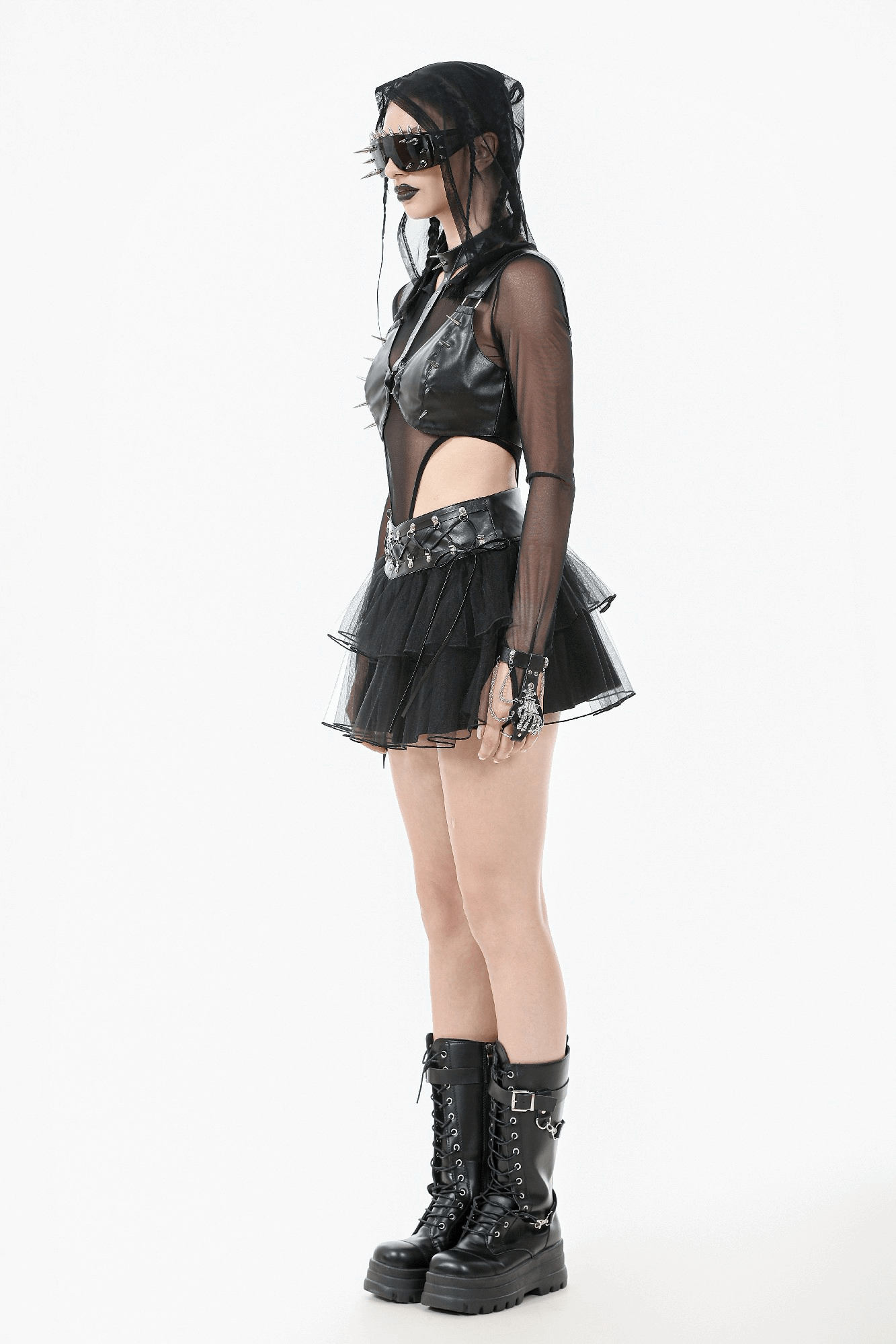Bold gothic outfit featuring a sheer top, layered skirt, and chunky black boots for edgy punk fashion.