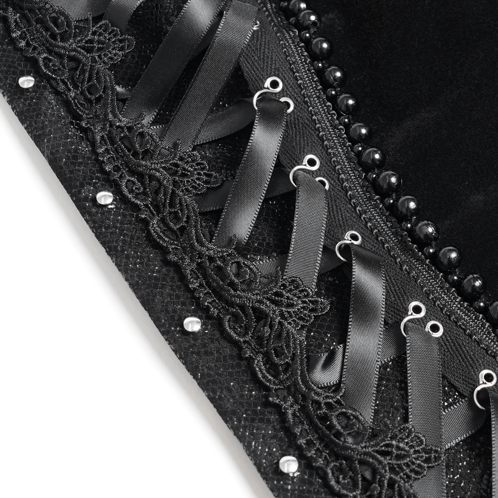 Close-up of bold black lace corset featuring satin ribbons, delicate lace trim, and sparkling embellishments.