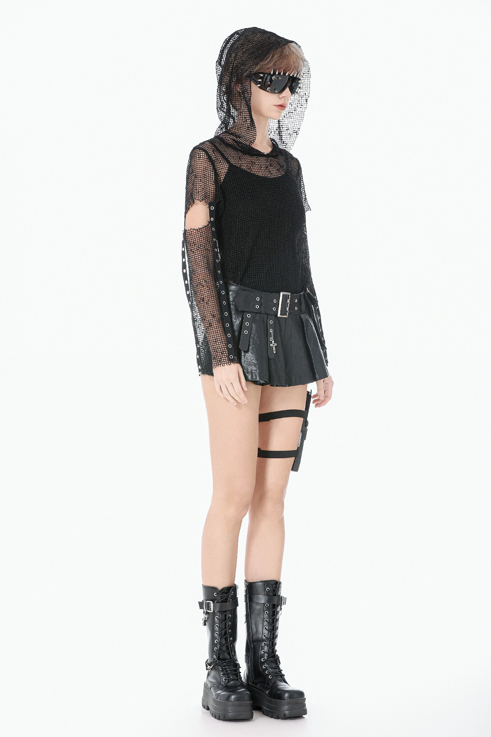 Bold Pleated Skirt Shorts with Belt and Cross Charm. Model wearing edgy gothic outfit with boots and unique accessories.