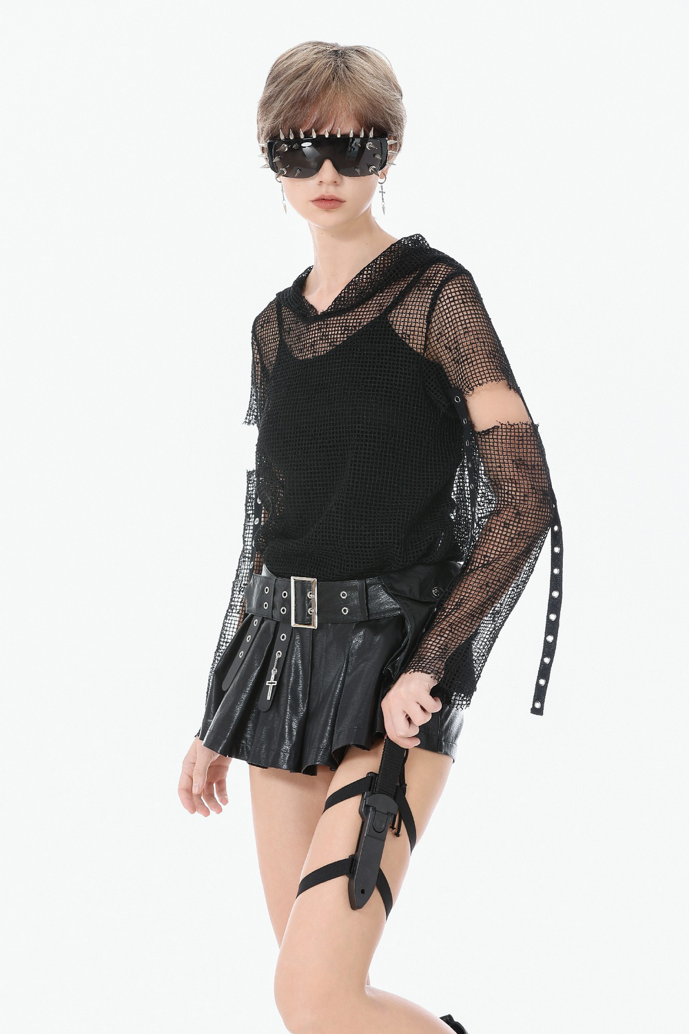Model wearing Bold Pleated Skirt Shorts with Belt and Cross Charm, showcasing a punk leather style with grommets.