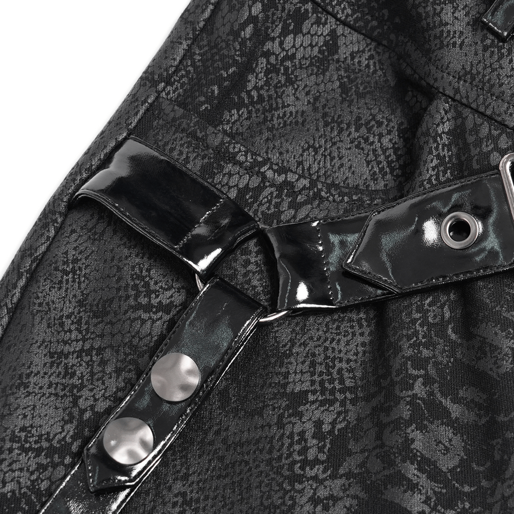 Close-up of buckled straps and snakeskin pattern on punk skinny pants with faux leather accents.