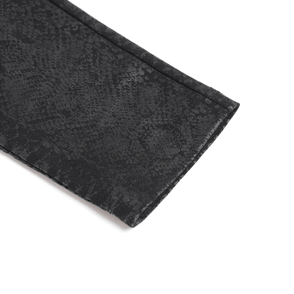 Detail of snakeskin-inspired pattern on bold skinny pants with sleek black texture and edgy design.