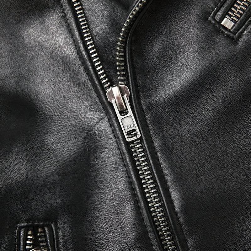 Close-up of the zipper detail on a men's genuine leather biker jacket, showcasing quality craftsmanship and sleek design.