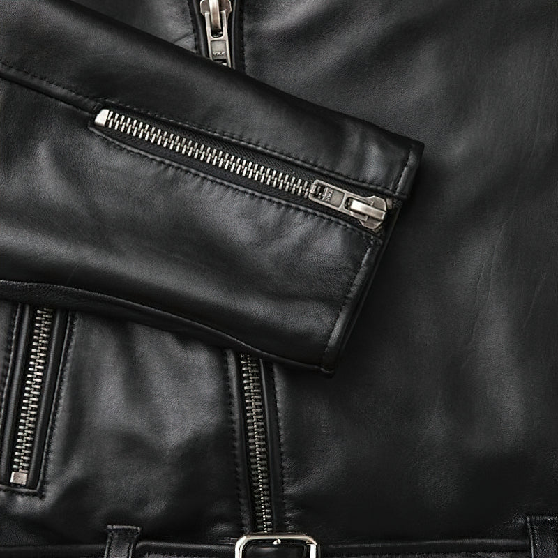 Close-up of a black genuine leather biker jacket sleeve with silver zippers and stitching details.