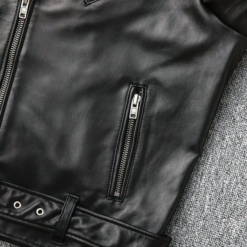 Close-up of a black genuine leather biker jacket, showcasing its zippers and minimalistic design.