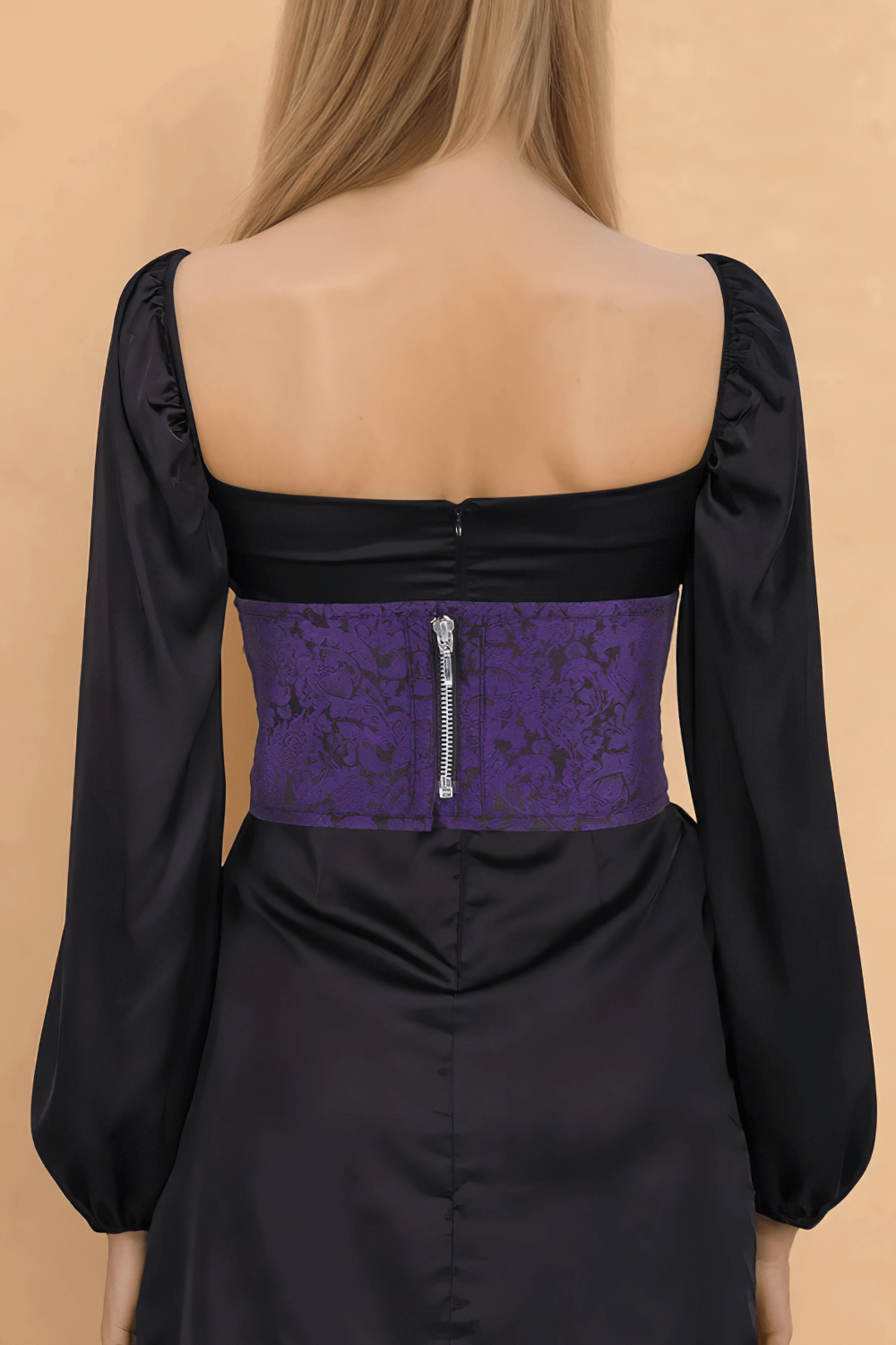 Back view of a woman wearing a purple brocade corset belt with zipper and lace-up, paired with a black dress.