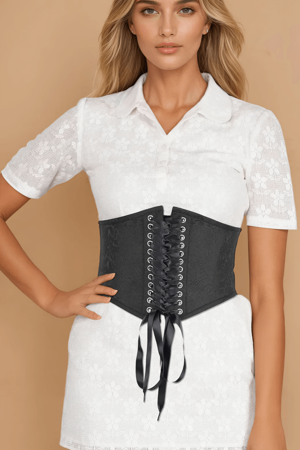 Elegant black brocade corset belt with lace-up front, styled over a white dress for a chic look.