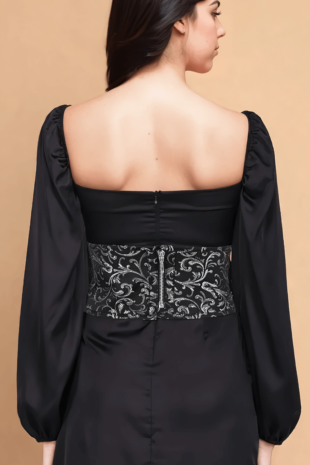 Elegant back view of a black dress with brocade corset-inspired belt and puff sleeves, showcasing intricate silver details.