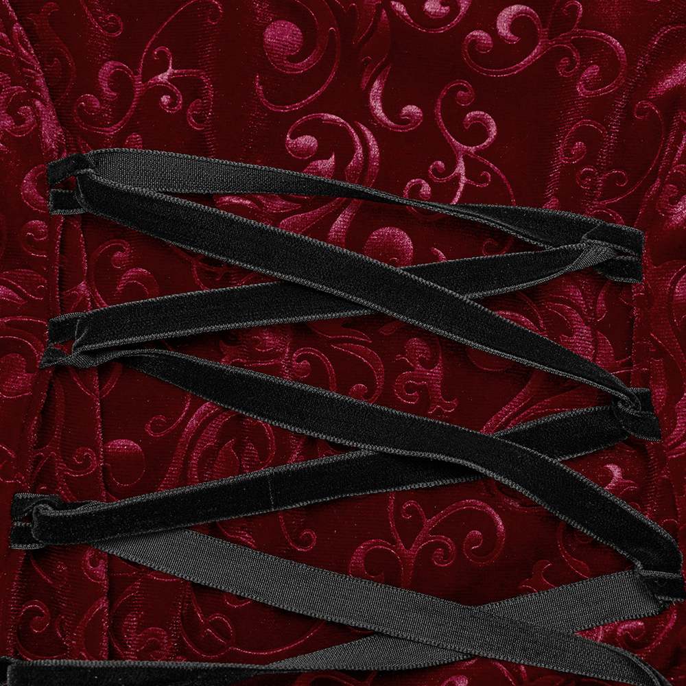 Close-up of burgundy embossed velvet with lace-up detailing, showcasing gothic elegance and intricate patterns.